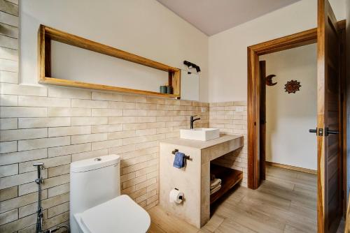 a bathroom with a white toilet and a sink at Villas Roca del Caribe in Puerto Viejo