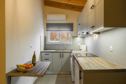 a kitchen with a sink and a bowl of fruit on a table at LazyDays in Analipsi in Análipsis
