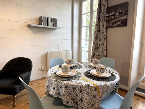 - une salle à manger avec une table, des tasses et des chaises dans l'établissement ღ Cordelier - Proche du port et du marché, Spacieux & Wi-Fi, à La Rochelle