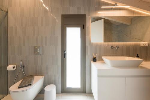 a bathroom with a toilet and a sink at Orama Luxury Apartments in Nea Kydonia