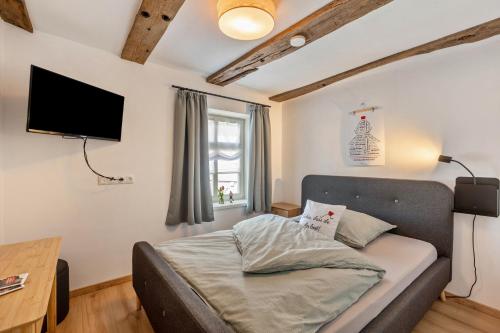 a bedroom with a bed and a flat screen tv at Zeihäänger Stubb in Schwalmstadt