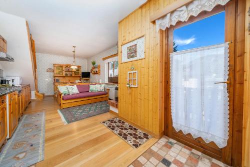 a kitchen and living room with a large window at Casa Margherita - Valbruna in Valbruna
