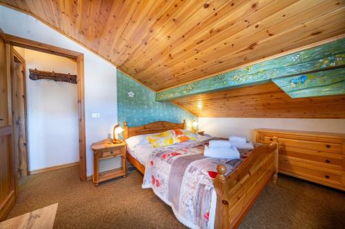 a bedroom with a bed and a wooden ceiling at Casa Margherita - Valbruna in Valbruna