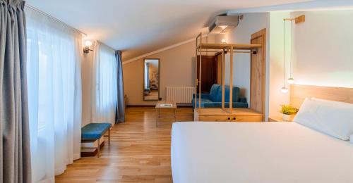 a bedroom with a white bed and a mirror at Spirit Hotel Ciudad de Burgos in Rubena