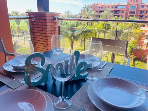 a table with wine glasses and a sign that says ally at La casa de Bimba Playa Granada in Motril