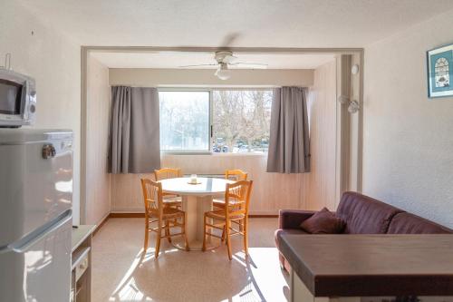 un salon avec une table, des chaises et un canapé dans l'établissement Le Petit QG, à Gruissan