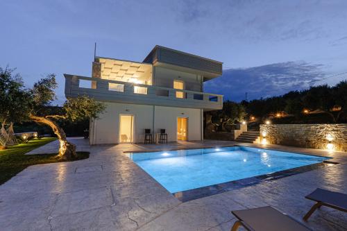 a house with a swimming pool in front of it at Villa Avelios in Karefilianá