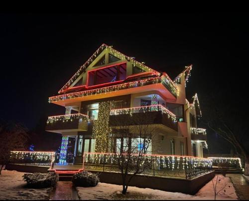 a house decorated with christmas lights in the night at Luca Residence Beautiful Villa in Trăisteni