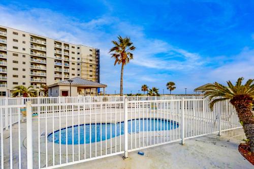 a white fence around a pool in front of a building at Plantation Dunes #5411 in Gulf Shores