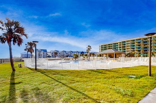 a resort with a white fence and palm trees at Plantation Dunes #5411 in Gulf Shores