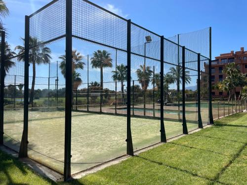 a tennis net on a tennis court with palm trees at La casa de Bimba Playa Granada in Motril