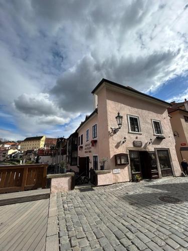 a building on a street with a cloudy sky at Pension Parkan in Český Krumlov