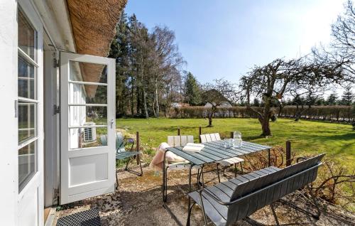 Hadsundにある3 Bedroom Amazing Home In Hadsundのパティオ(テーブル、椅子、窓付)