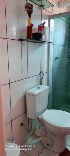 Un baño con inodoro y ducha de cristal. en hospedagem, en Lençóis