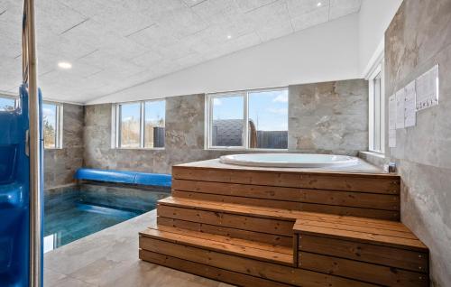 a large bathroom with a tub and a swimming pool at Nice Home In Højslev With Sauna in Højslev