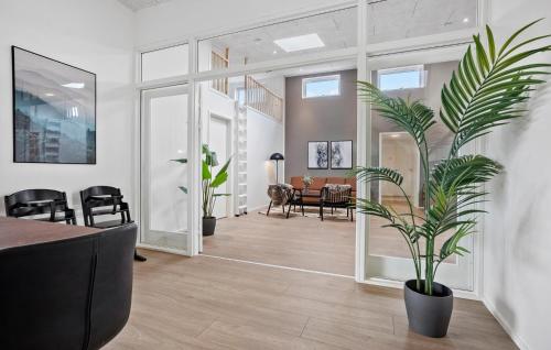 a living room with a potted plant and a dining room at Nice Home In Højslev With Sauna in Højslev