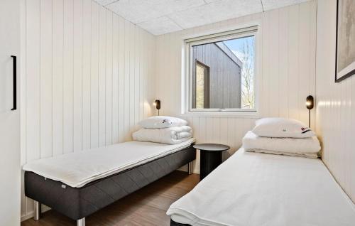 two beds in a room with a window at Nice Home In Højslev With Sauna in Højslev