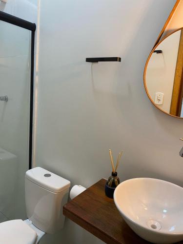 a bathroom with a sink and a toilet and a mirror at Quarto Duplo Nova Mutum in Nova Mutum