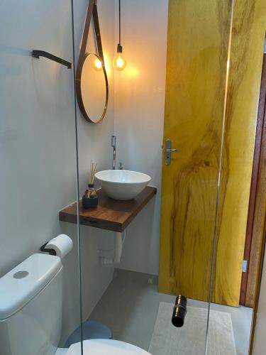 a bathroom with a sink and a toilet and a mirror at Quarto Duplo Nova Mutum in Nova Mutum