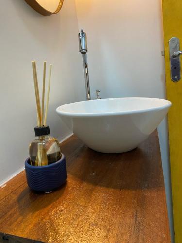a white bowl sitting on a wooden floor in a bathroom at Quarto Duplo Nova Mutum in Nova Mutum