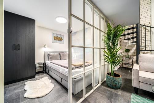 a bedroom with a bed and a potted plant at Paulay at Opera Suites P39 in Budapest