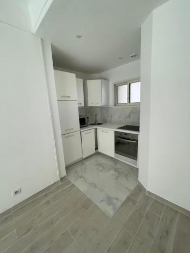 une cuisine avec des armoires blanches et un plancher en bois dans l'établissement 