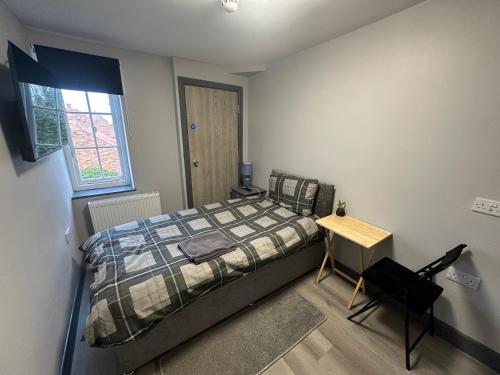 a bedroom with a bed and a desk and a window at High street apartments in Boston
