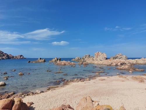 a beach with rocks and the ocean on a clear day at Il Rumore del Mare Beach House in Trinità dʼAgultu