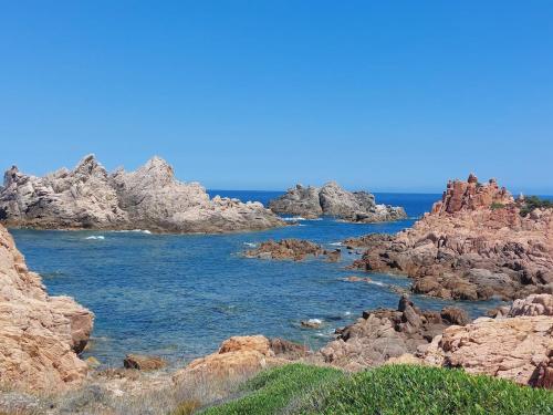 a group of rocks in the water near the ocean at Il Rumore del Mare Beach House in Trinità dʼAgultu