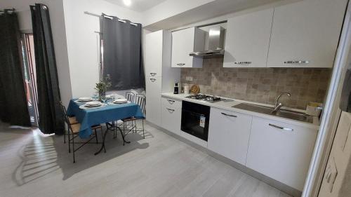 a small kitchen with a table and a sink at Il Rumore del Mare Beach House in Trinità dʼAgultu