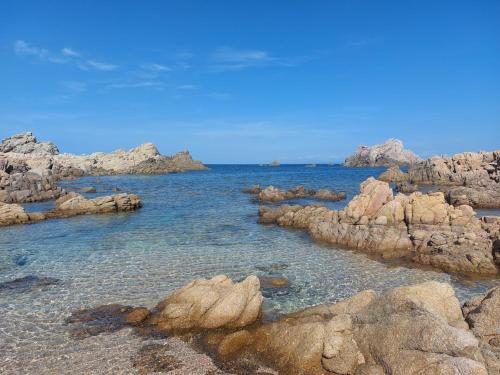 a group of rocks in the water near the ocean at Il Rumore del Mare Beach House in Trinità dʼAgultu