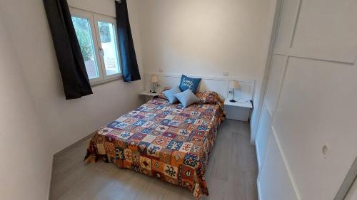 a small bedroom with a bed and a window at Il Rumore del Mare Beach House in Trinità dʼAgultu