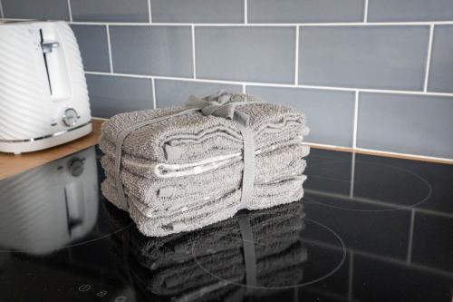 a stack of towels on a counter in a kitchen at Stirling Street Stays in Tillicoultry