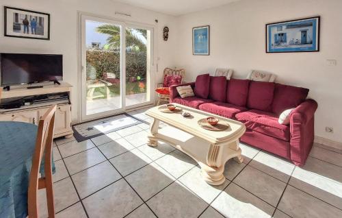 Una sala de estar con un sofá rojo y una mesa. en Holiday Home Fleurac P-697, en Plouguerneau