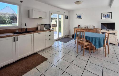 une cuisine avec des placards blancs et une table avec un chiffon bleu dans l'établissement Holiday Home Fleurac P-697, à Plouguerneau