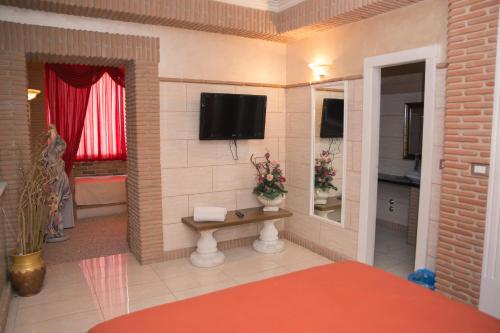 a room with a television on a wall with a table at Il Castello di Perano in Perano