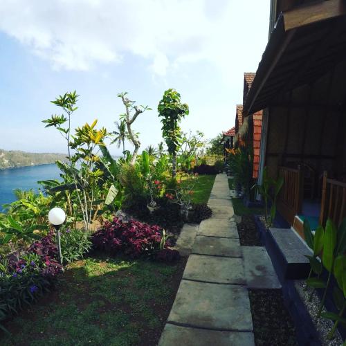 a walkway in front of a house with flowers at Sakti OceanView Nusa Penida in Nusa Penida