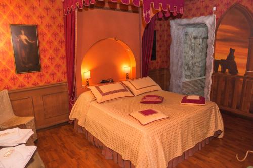a bedroom with a bed with two red pillows on it at Il Castello di Perano in Perano