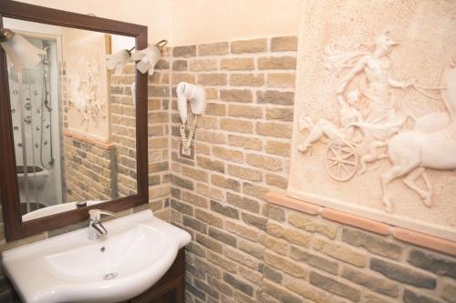 a bathroom with a sink and a brick wall at Il Castello di Perano in Perano