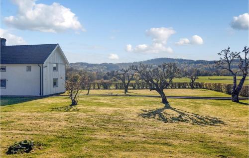 a white house in a grassy field with trees at 5 Bedroom Beautiful Home In Björketorp in Björketorp