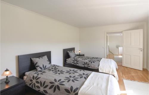 a white bedroom with two beds and a door at 5 Bedroom Beautiful Home In Björketorp in Björketorp