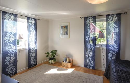 a bedroom with blue and white curtains and a window at 5 Bedroom Beautiful Home In Björketorp in Björketorp