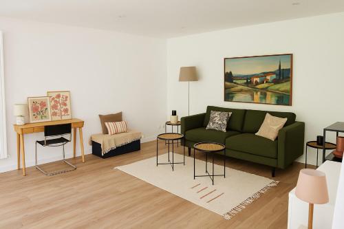 un salon avec un canapé vert et une table dans l'établissement Bel appartement avec terrasse et jardin, à Vaux-le-Pénil