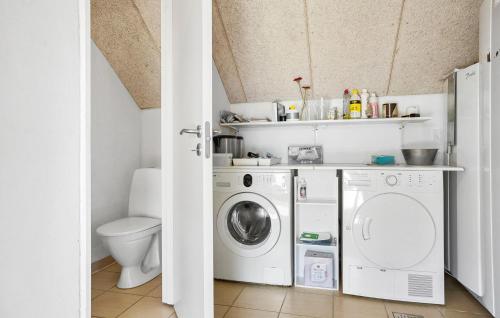 a bathroom with a washing machine and a toilet at Amazing Home In Vinderup With Sauna in Vinderup