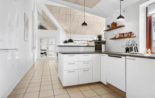 a kitchen with white cabinets and a tile floor at Amazing Home In Vinderup With Sauna in Vinderup