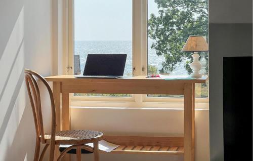 a laptop sitting on a desk in front of a window at Lovely Home In Trelleborg With Sauna in Trelleborg