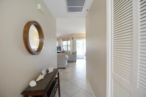 a hallway with a table and a mirror on a wall at Beach Access - Tennis - Two Pools - Fishing Dock in Siesta Key