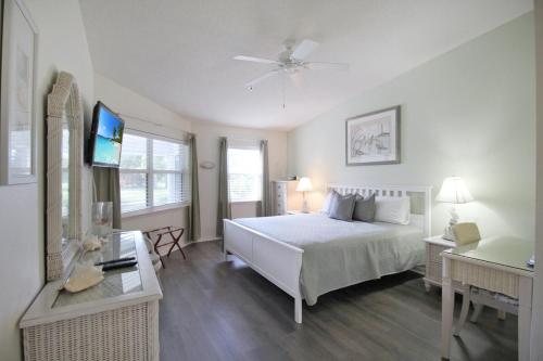 a bedroom with a bed and a television in it at Beach Access - Tennis - Two Pools - Fishing Dock in Siesta Key