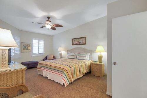 a bedroom with a bed and a ceiling fan at Spacious 2BR Siesta Key condo with private beach access in Siesta Key