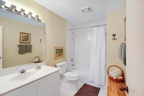 a white bathroom with a sink and a toilet at Spacious 2BR Siesta Key condo with private beach access in Siesta Key